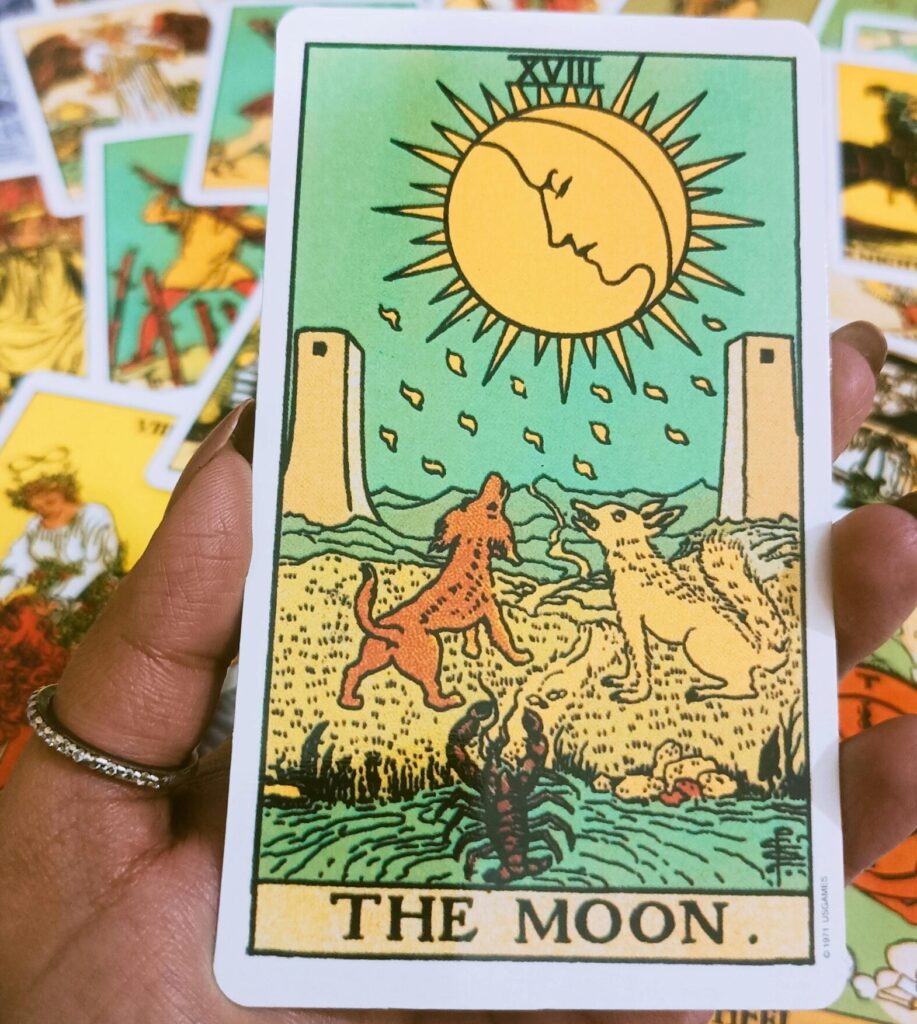 A close-up of The Moon tarot card held in hand, ideal for spiritual themes.